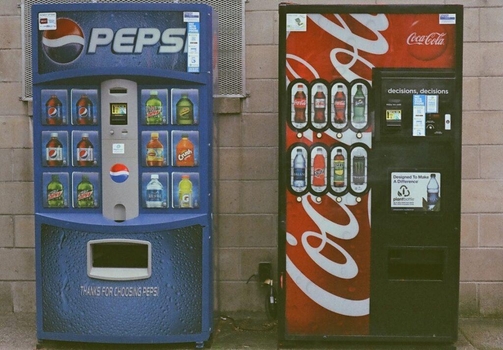 מכונות שתיה אוטומטיות: מימין מכונה של קוקה קולה, משמאל מכונה של פפסי קולה
